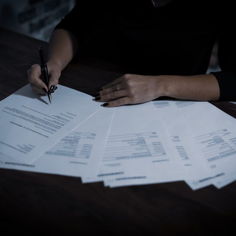 a woman sitting at a table with lots of papers
